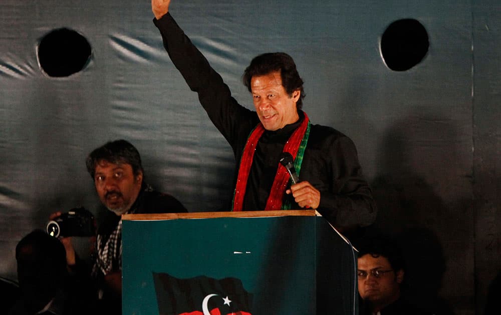 Imran Khan, head of Pakistan Tehreek-e-Insaf or Movement for Justice, raises his arm for his supporters during a rally in Islamabad.