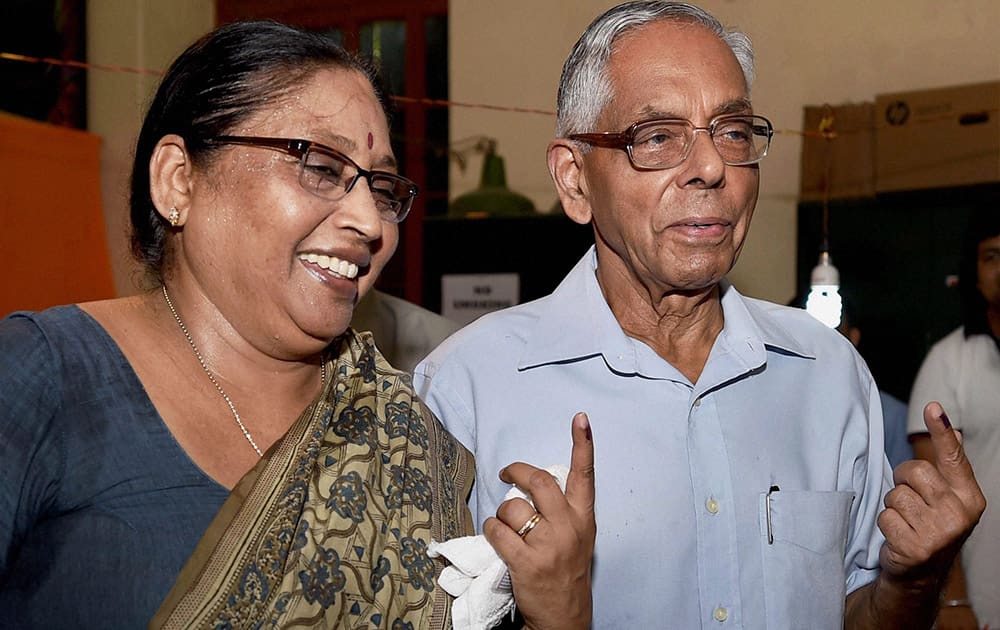 West Bengal Governor M K Narayanan and his wife Padmini Narayanan showing their ink-marked fingers after casting their votes in Kolkata.