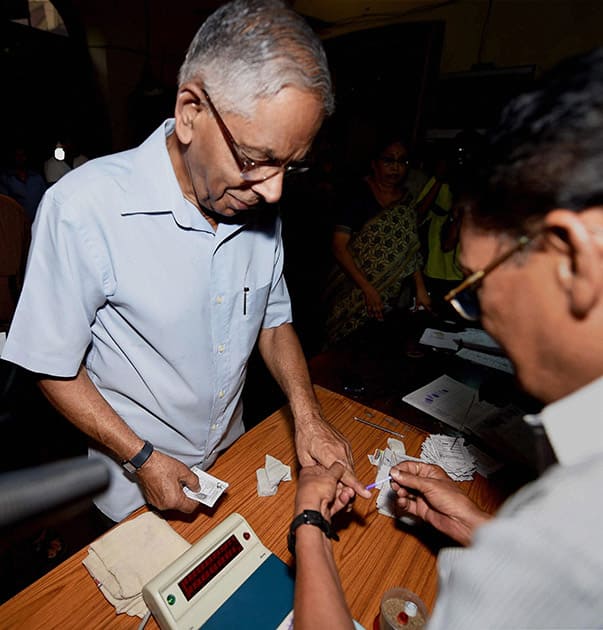 West Bengal Governor M K Narayanan gets his finger inked before casting his vote at a polling station during the last phase of Lok Sabha polls in Kolkata .