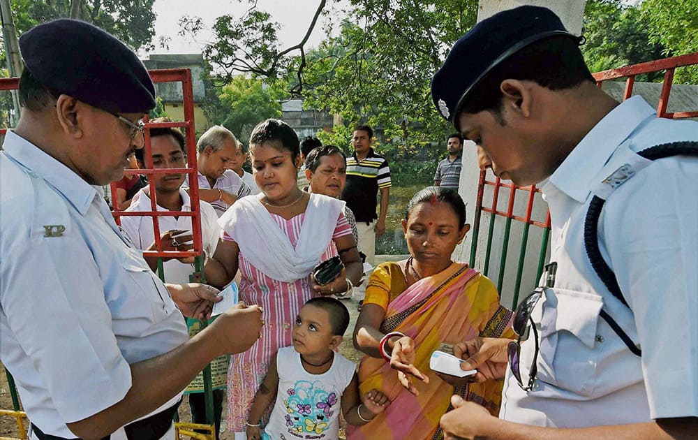 Policemen checking identity cards of voters outside a polling booth during the last phase of Lok Sabha polls in Kolkata.