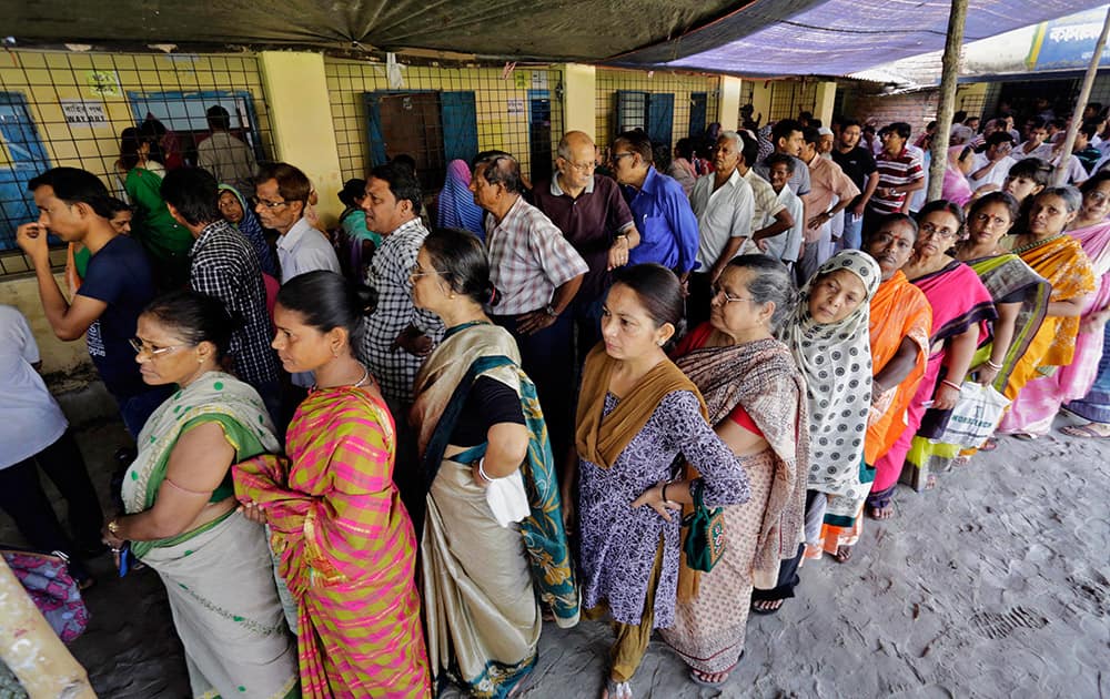 People stand in a queue to cast their vote at a polling station in Kamalgaji, on the outskirts of Kolkata.