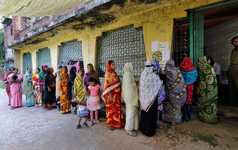 People stand in a queue to cast their vote at a polling station in Kamalgaji, on the outskirts of Kolkata.