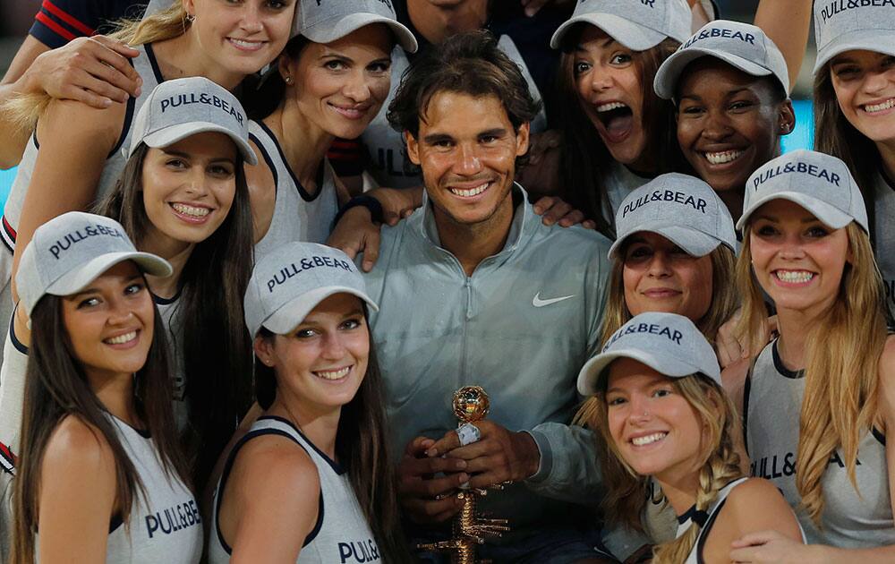 Rafael Nadal from Spain, centre, displays his trophy, as he poses with the ball girls, after the Madrid Open tennis tournament men`s final match against Kei Nishikori from Japan.