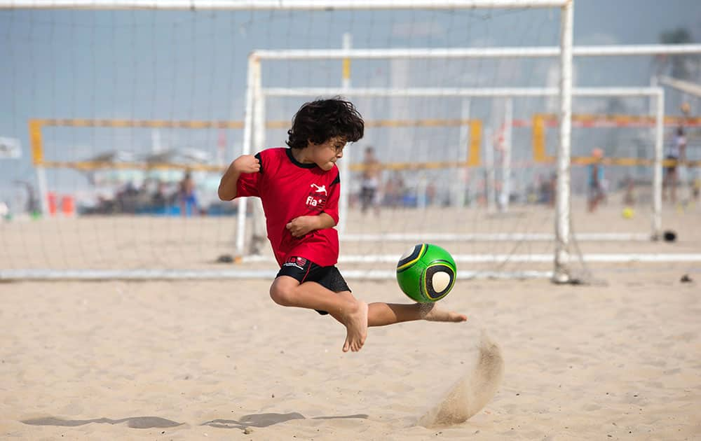 A boy controls the ball as he trains on Ipanema beach in Rio de Janeiro, Brazil.