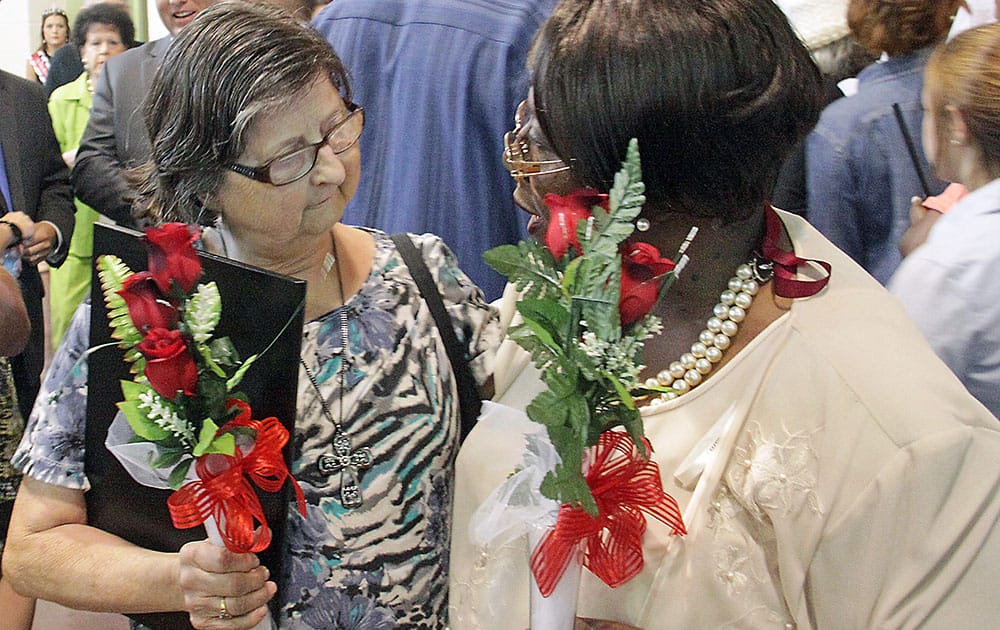 Connie Buggs, left, and Nancy Dupree, who both lost family members in the April 28, 2014, tornado attend a community memorial service for the 10 Winston County residents killed in Louisville, Miss.