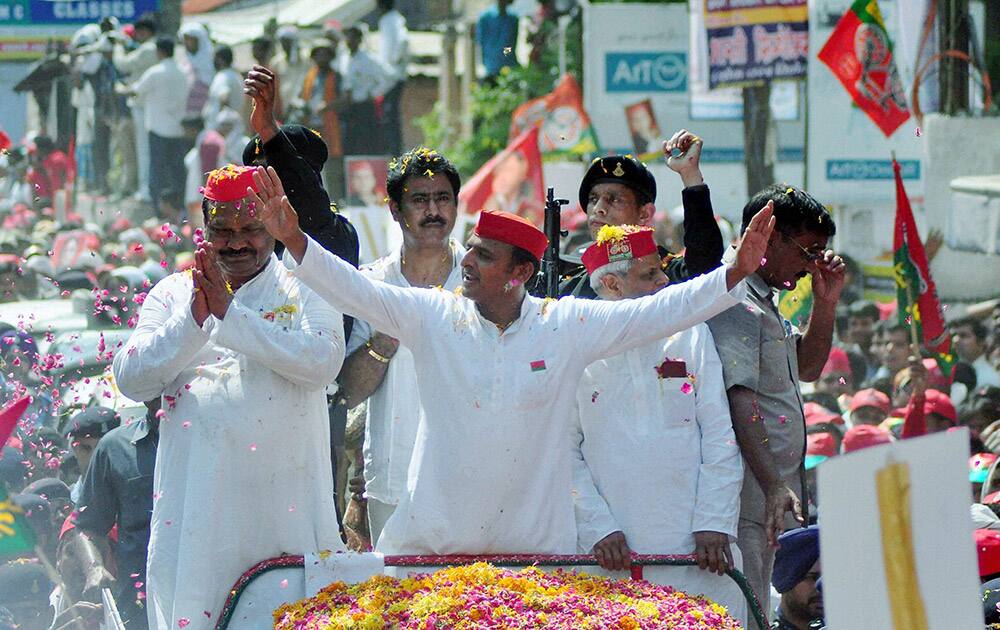 Uttar Pradesh Chief Minister Akhilesh Yadav shakes hands with Samajwadi party supporters during an election campaign road show in Varanasi.