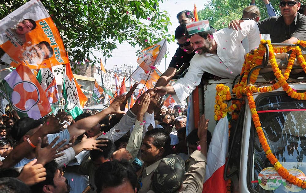 Congress Vice President Rahul Gandhi shakes hands with supporters during an election road show in Varanasi.