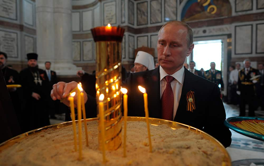 Russian President Vladimir Putin lights a candle in Sevastopol where he attends celebrations marking the Victory Day, in Crimea.