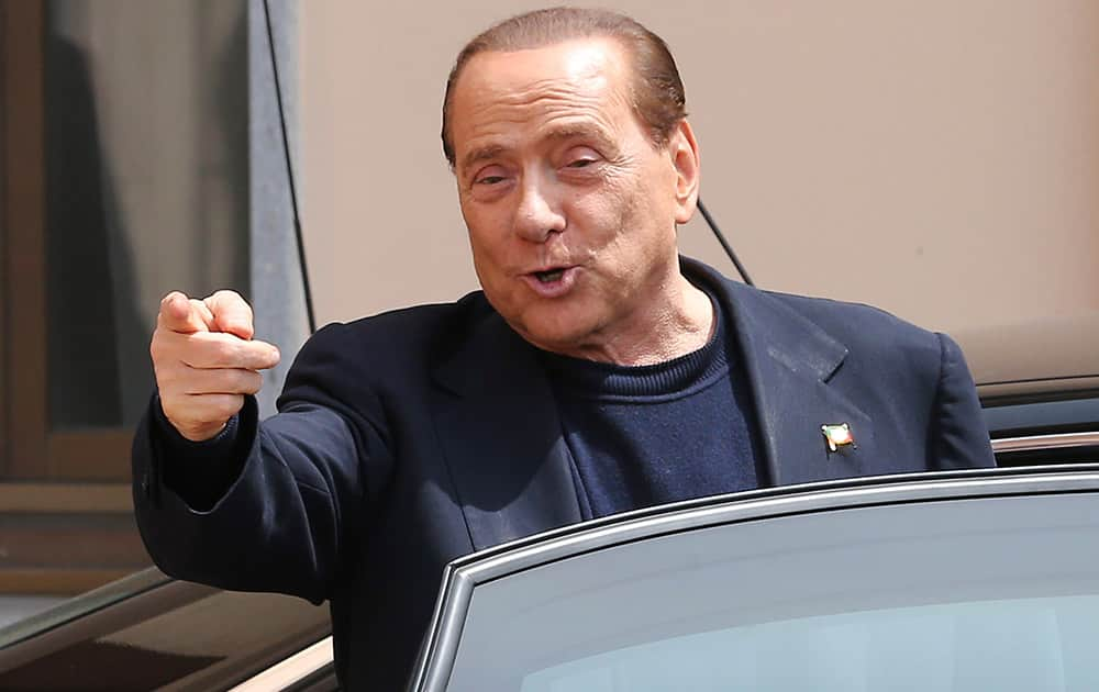 Former Italian Premier Silvio Berlusconi smiles as he leaves the `Sacra Famiglia` foundation in Cesano Boscone, near Milan, Italy. Berlusconi, 77, was ordered to perform four hours of community service a week for a year after his four-year sentence was reduced to one by a general amnesty.