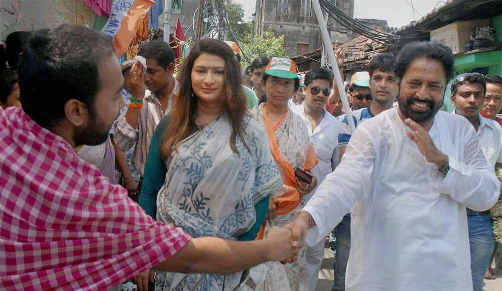 Trinamool Congress candidate Sudip Bandyopadhay with his wife and actress Naina Das Bandopadhay (C) during his election campaign rally for Lok Sabha polls, at a slum area in Kolkata.