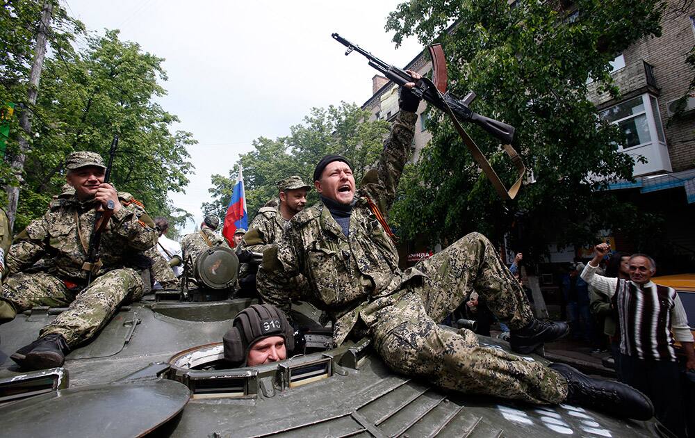 Pro-Russian gunmen atop an armored personal carrier shout slogans during a Victory Day celebration, which commemorates the 1945 defeat of Nazi Germany, in the center of Slovyansk, eastern Ukraine.