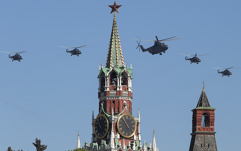 Russian Air Force helicopter Mi-26, center, with Mi-8, flies over Red Square during a Victory Day parade, which commemorates the 1945 defeat of Nazi Germany, in Moscow, Russia.