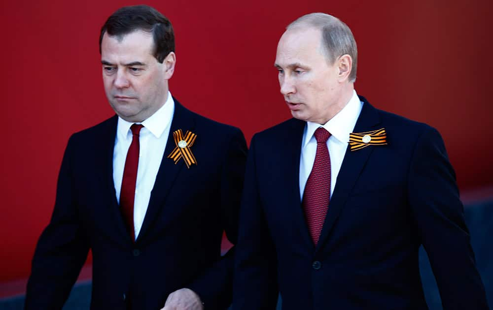 Russian President Vladimir Putin and Prime Minister Dmitry Medvedev, wearing ribbons symbolizing the Soviet victory in WWII, arrive to attend the Victory Day Parade, which commemorates the 1945 defeat of Nazi Germany, in Moscow, Russia.