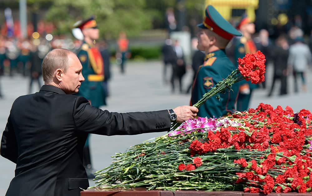 Russian President Vladimir Putin lays flowers during a wreath laying ceremony at the Tomb of Unknown Soldier, at the Kremlin wall on the eve of Victory Day in Moscow, Russia.