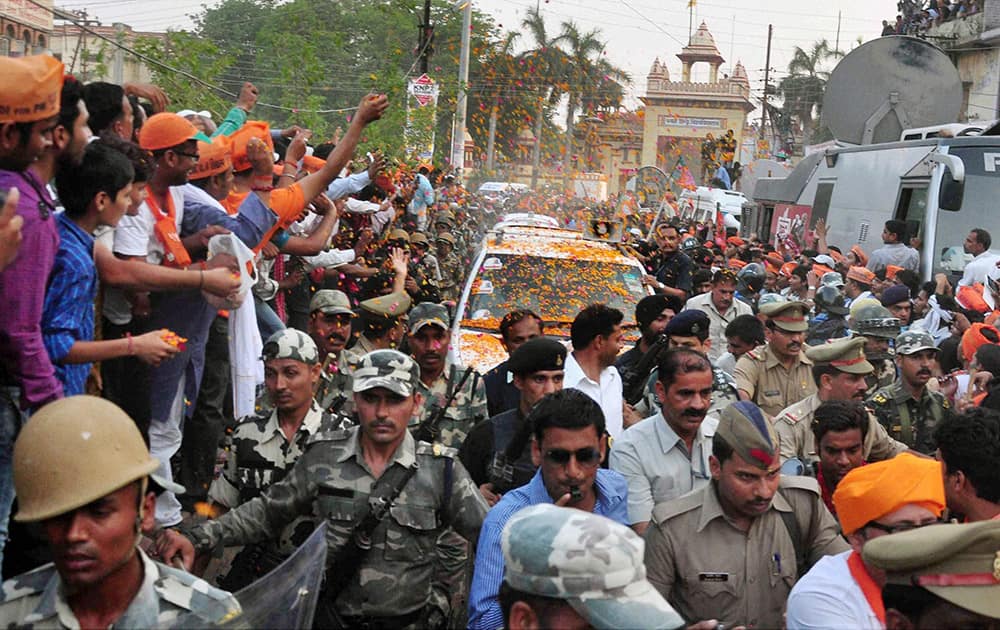 People showing flowers on BJP PM candidate Narendra Modi`s vehicle during an election road show in Varanasi.