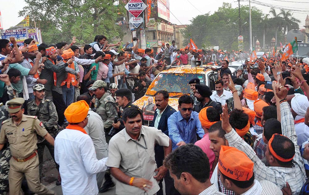 Supporters cheer during BJP PM candidate Narendra Modi`s election road show in Varanasi.