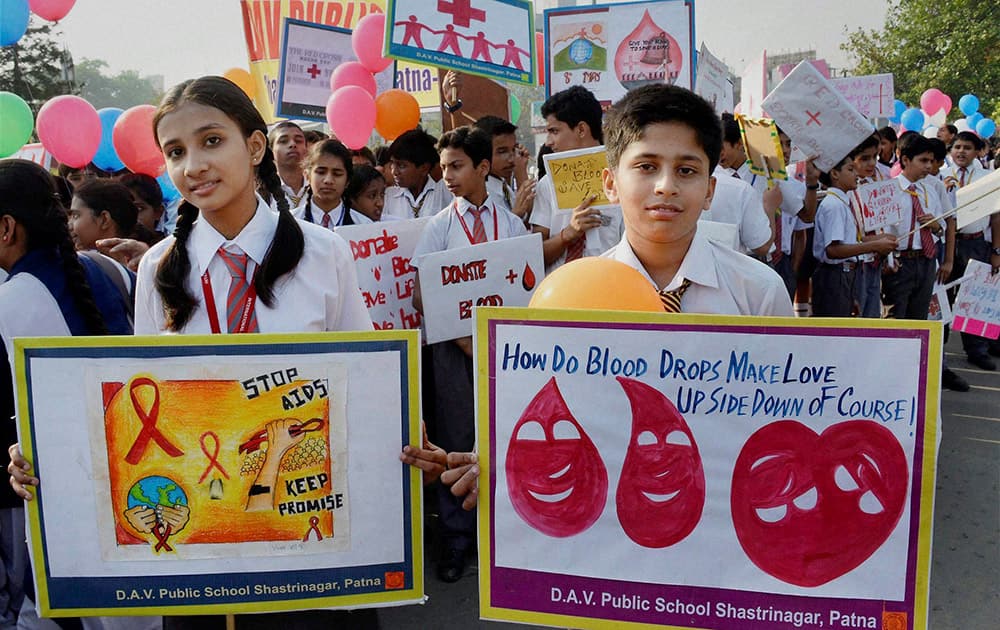 School students carry placards during an awarness rally on World Red Cross Day in Patna.