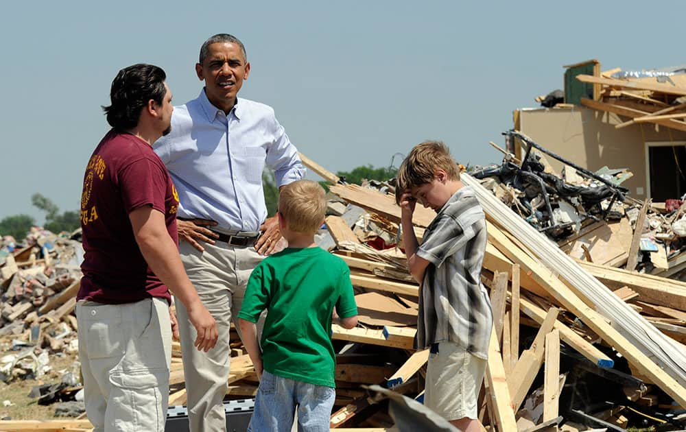 President Barack Obama tours tornado-damaged areas of Vilonia, Ark., and talks with Daniel Smith and his sons Garrison Dority and Gabriel Dority, right. Obama is visiting with first responders and families affected by the recent tornados before traveling on to California where he will raise money for the Democratic Party and receive an award from a foundation created by movie director Steven Spielberg. 