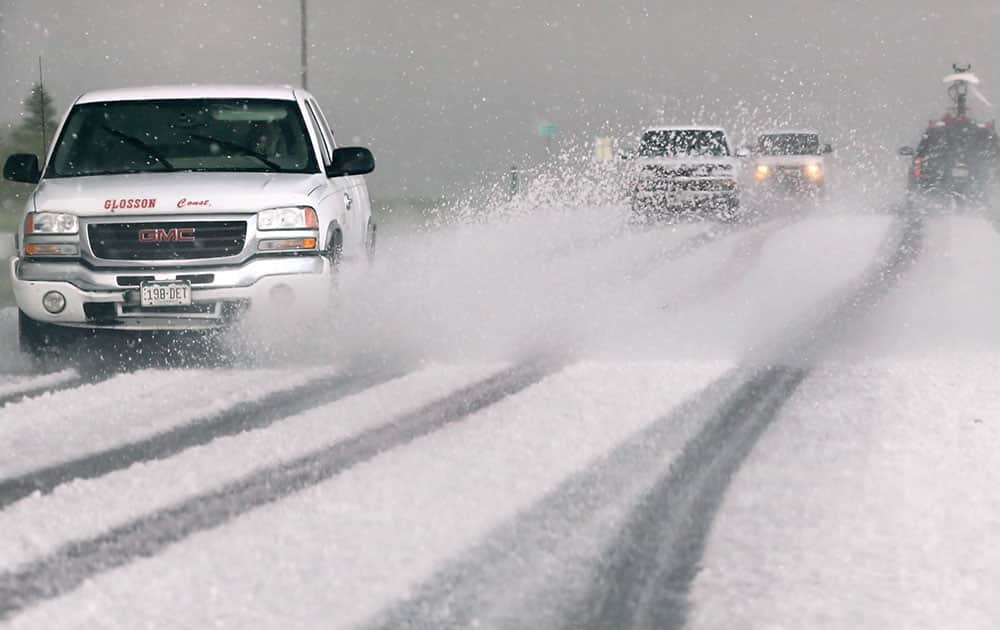 Vehicles try and make their way through hail covered roads after a tornado touched down in Akron, Colo. during a severe weather outbreak.