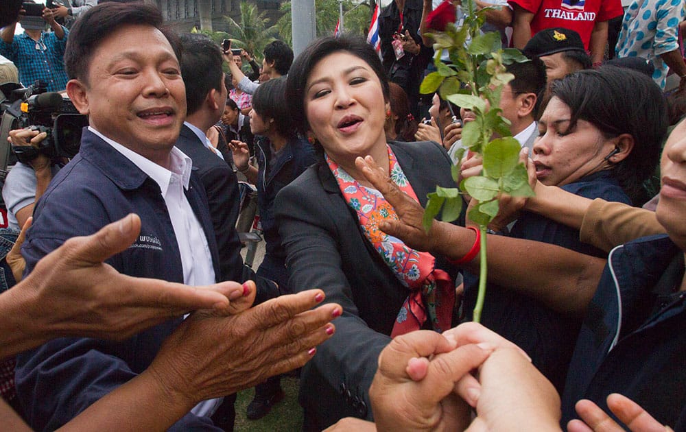 Thai Prime Minister Yingluck Shinawatra shakes hand with her supporters in Bangkok.