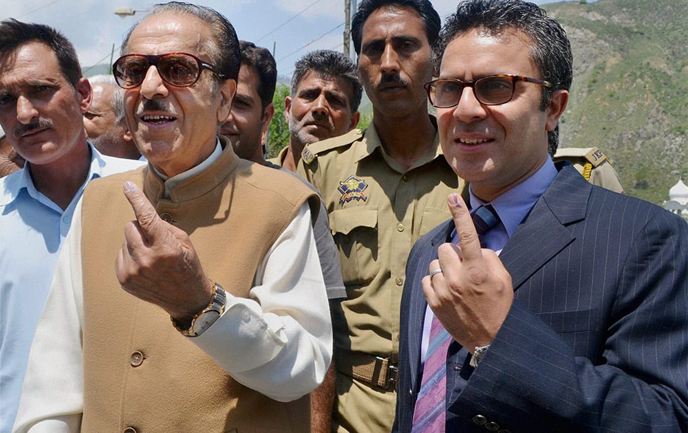 Jammu and Kashmir Pradesh Congress Committee (JKPCC) chief Saifuddin Soz and his son Salman Soz show their inked fingers after casting votes for Lok Sabha polls at a polling station at Khanpora in Baramulla.