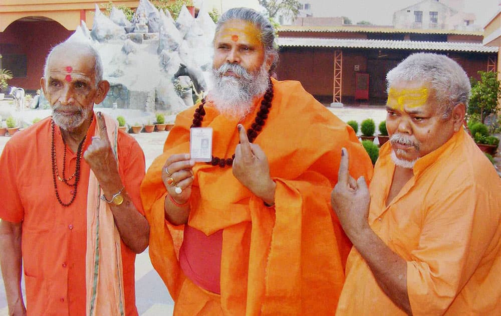 Mahant Narendra Giri Ji Maharaj and other sadhus show their inked fingers in Allahabad.