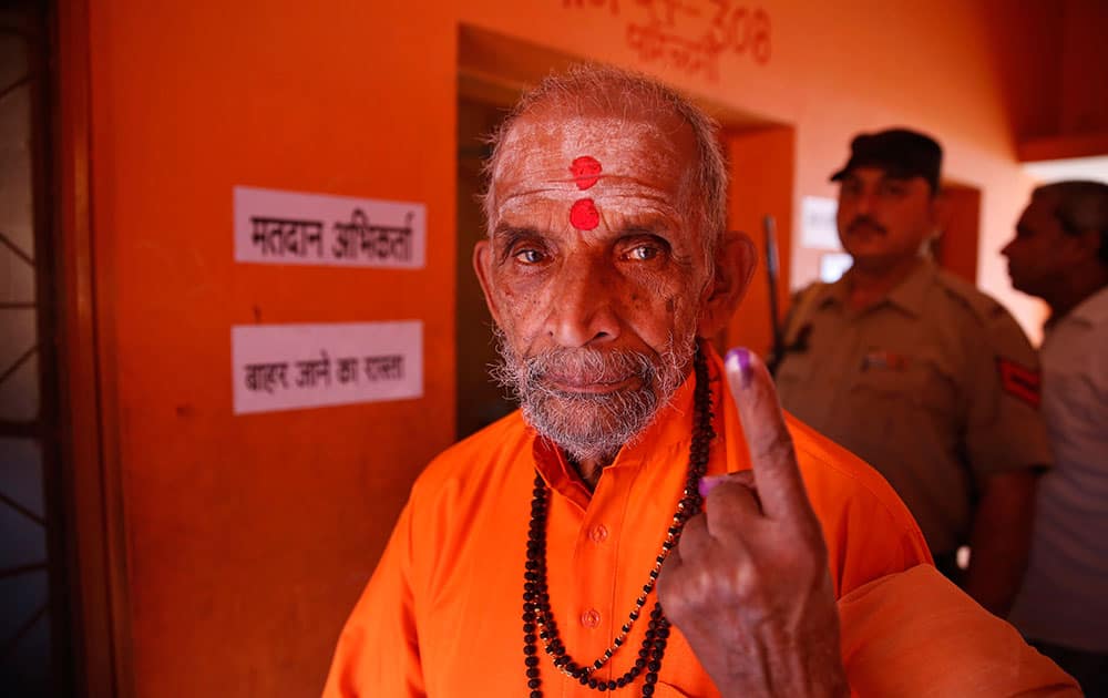 A Hindu holy man displays the indelible ink mark on his finger as he returns after casting his vote during the eighth phase of voting of the Indian parliamentary elections in Allahabad.