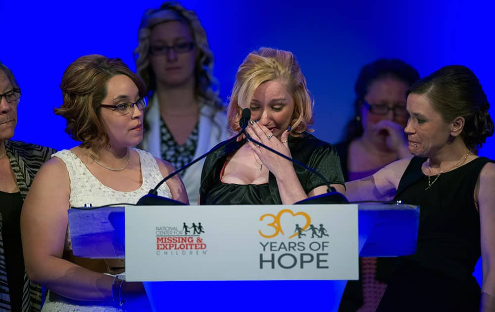 On the one-year anniversary of their escape, Cleveland, Ohio kidnapping survivors Amanda Berry, right, wipes tears from her eyes as Georgina DeJesus, left, looks on as they are honored at the annual National Center for Missing and Exploited Children`s Hope Awards dinner in Washington.