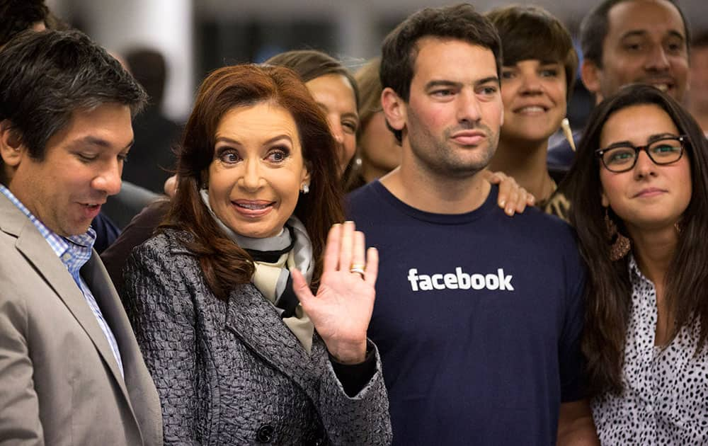 Argentine President Cristina Fernandez waves to photographers as she meets employees during a tour of the new Facebook offices` in Buenos Aires, Argentina.