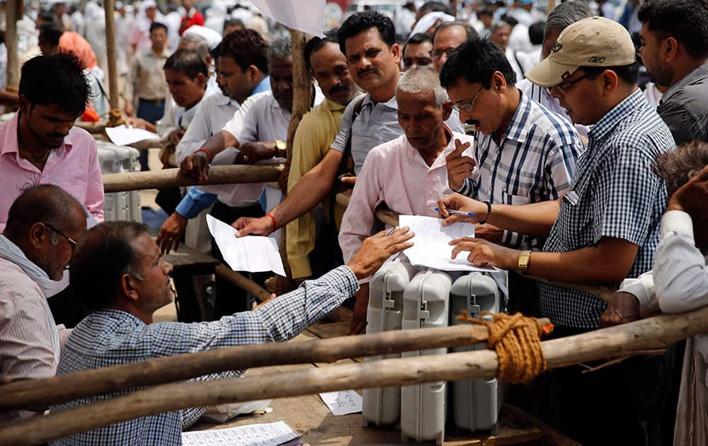 Election officers crowd around a distribution center to receive electronic voting machines for their respective polling stations on the eve of polling in Allahabad, in the northern Indian state of Uttar Pradesh.