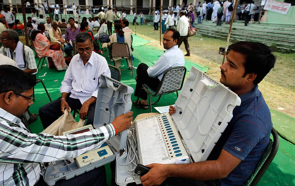 Election officers check an electronic voting machine before proceeding to their allotted polling stations, on the eve of polling in Allahabad, in the northern Indian state of Uttar Pradesh.