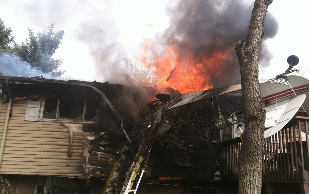 This photo provided by North Metro Fire Rescue District, a house is on fire after a plane crash, Northglenn, Colo. The pilot, Brian Veatch said that he once owned the home, as indicated by property records, but said he didn`t realize that`s where he crashed until someone else pointed it out.