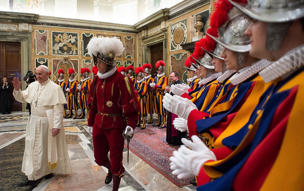 Pope Francis, flanked by Swiss Guards Commander Daniel Rudolf Anrig, greets new Swiss Guards the day before their swearing-in ceremony, as he arrives to meet them in the Clementine hall at the Vatican.