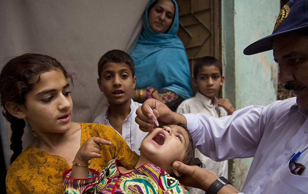 A Pakistani health worker gives a polio vaccine to a child in Rawalpindi, Pakistan.