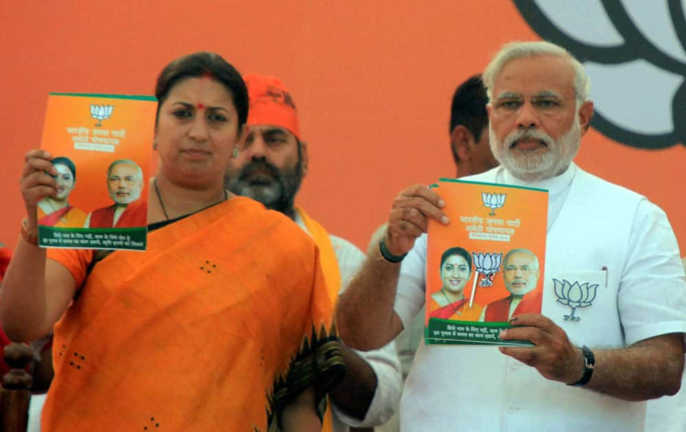 BJP PM candidate Narendra Modi along with party candidate Smriti Irani releases the party`s election manifesto for Amethi during a rally in Amethi.