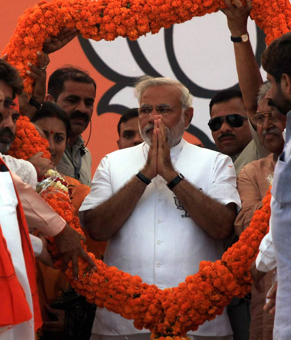 BJP PM candidate Narendra Modi is garlanded during an election rally in Amethi.