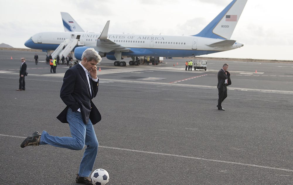 US Secretary of State John Kerry kicks around a soccer ball during an airplane refueling stop at Sal Island, Cape Verde, enroute to Washington.