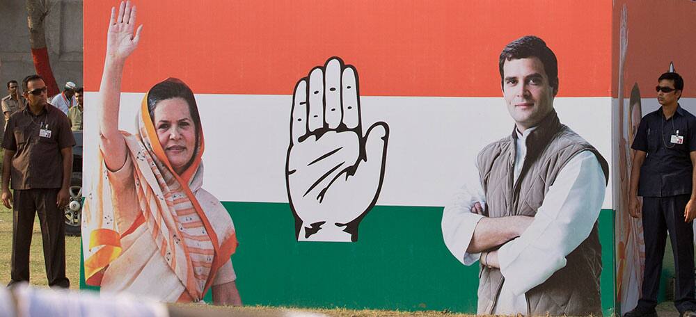 Security men guard beneath the dais as India’s ruling Congress party vice president Rahul Gandhi, photograph on right, addresses an election campaign rally in Allahabad.