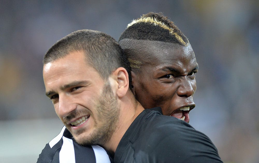 Juventus players Paul Pogba, right, and Leonardo Bonucci, left, celebrate at the end of a Serie A soccer match againsts Atalanta, at the Juventus stadium, in Turin, Italy.