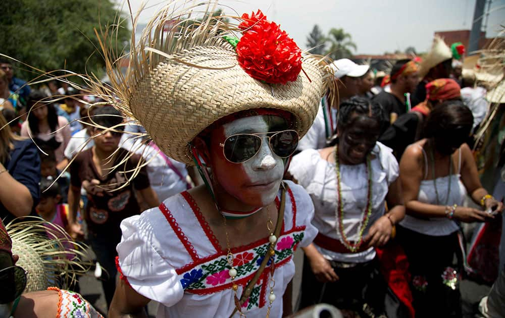 A man dressed as a revolutionary Zacapoaztla Indian female soldier dances during a re-enactment of the battle of Puebla between the Zacapoaztlas Indians and French army at the Cinco de Mayo celebrations, in Mexico City.