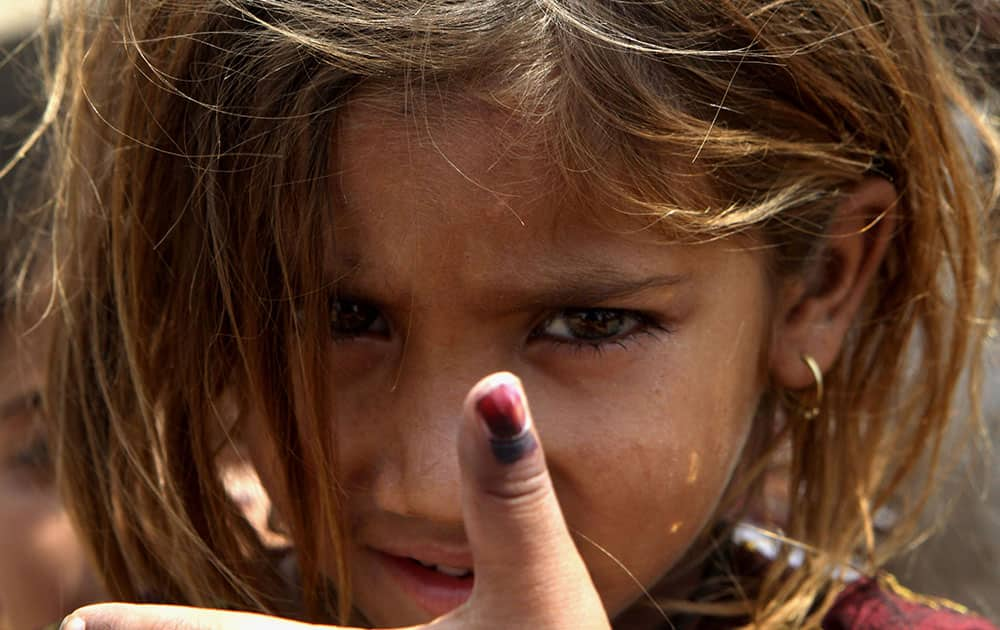 Pakistani girl Amina shows her thumb being marked after receiving polio vaccine in Lahore, Pakistan.