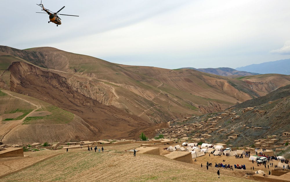 Survivors walk near the site of Friday`s landslide that buried Abi-Barik village in Badakhshan province, northeastern Afghanistan.