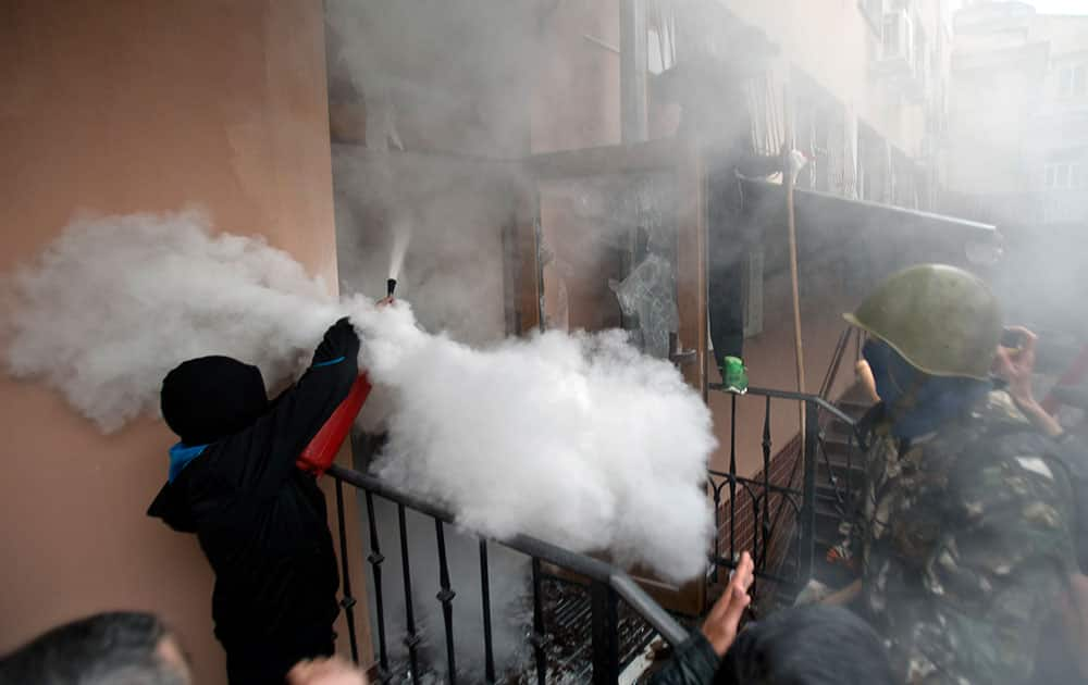 A pro-Russian protester fires a fire extinguisher at riot police inside at a police station building in Odessa, Ukraine.