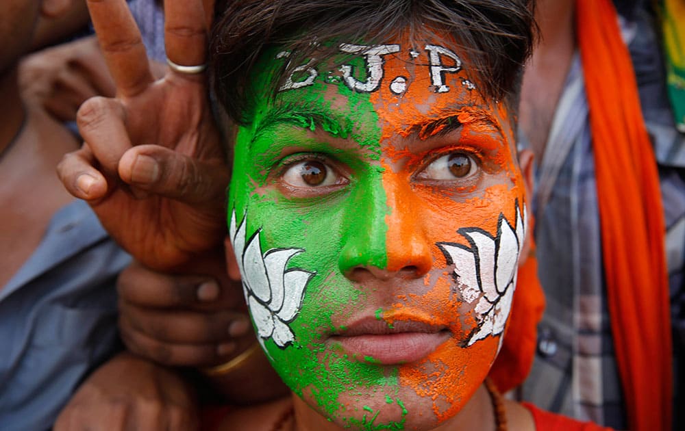 A supporter who has his face painted with party symbol, `lotus` stands at a campaign rally addressed by India’s main opposition Bharatiya Janata Party’s prime ministerial candidate Narendra Modi ahead of the Indian parliamentary elections in Allahabad.