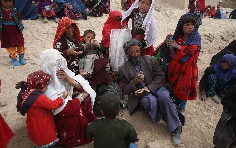 Survivors wait to receive donations near the site of Friday`s landslide that buried Abi-Barik village in Badakhshan province, northeastern Afghanistan.