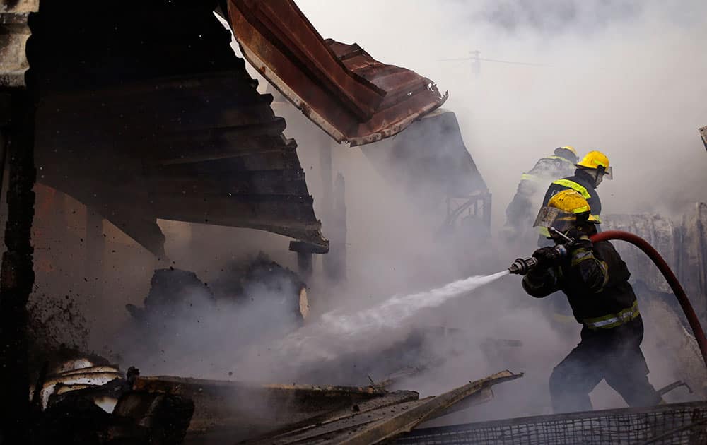 Firemen work to stop a Shack fire that destroyed up to twenty homes in Gugulethu township on the outskirts of the city of Cape Town, South Africa.