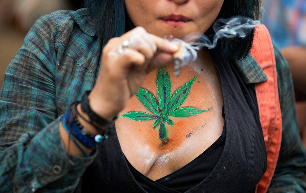 A young woman smokes a joint during a rally calling for the legalization of marijuana, in Mexico City.