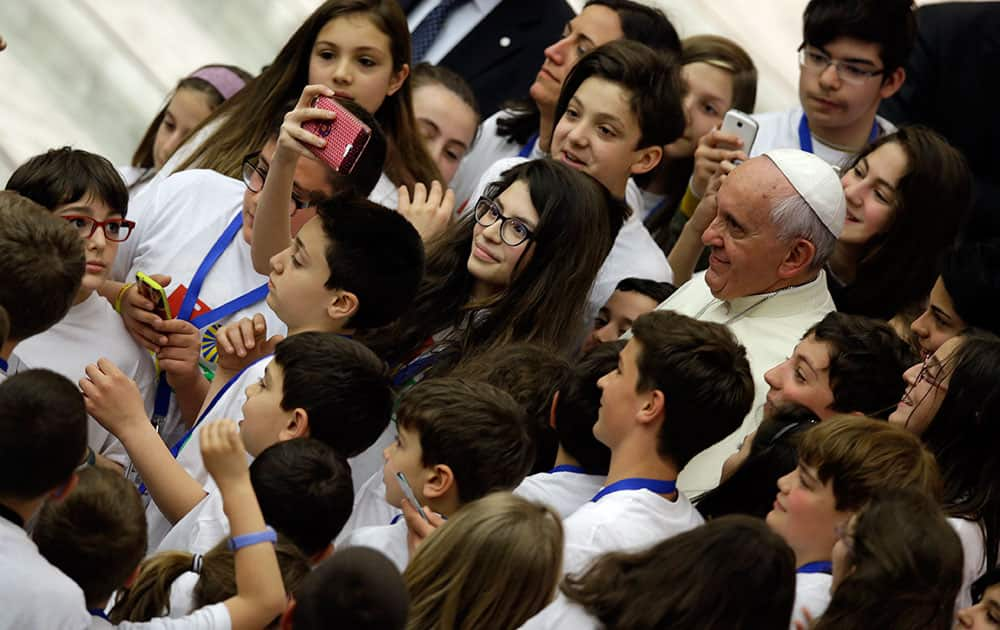 Pope Francis poses for a picture with children, at the end of a meeting with an Italian catholic group, in the Paul VI hall at the Vatican.