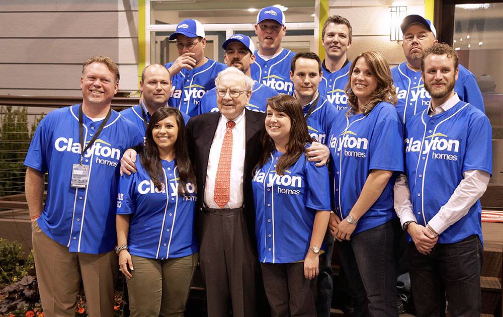 Billionaire investor Warren Buffett poses for a photo with employees of Clayton Homes, a Berkshire Hathaway subsidiary, while touring the exhibition floor in Omaha, Neb.