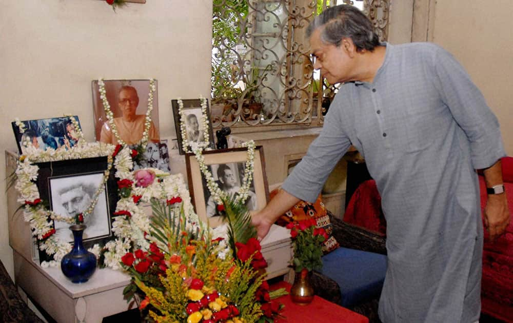 Sandip Ray,son of legendary film director Satyajit Ray,pays tribute to his father`s potraits on his 93rd birth anniversary,at his residence in Kolkata.